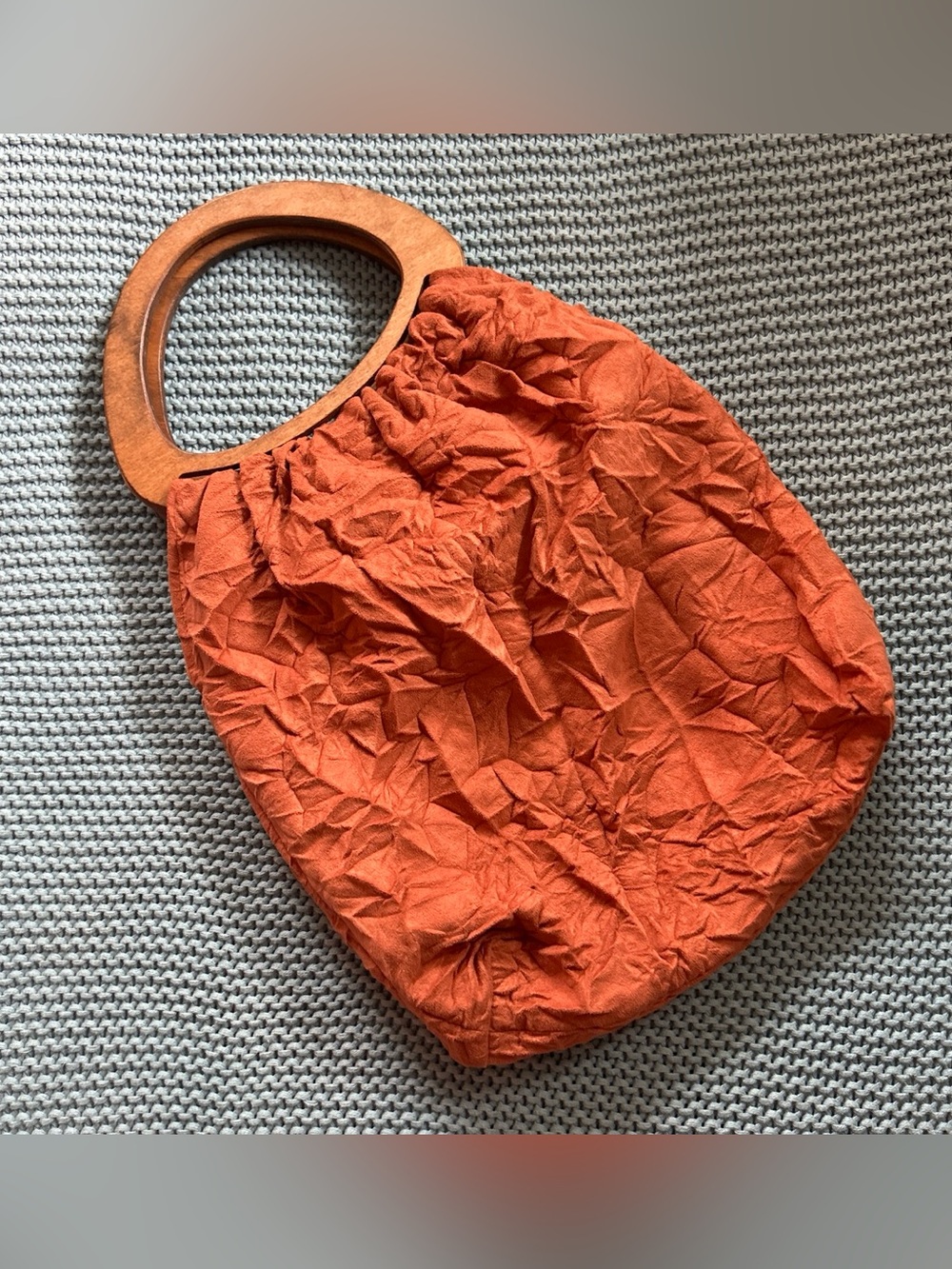 Vintage orange crinkled fabric handbag, wood handle and floral pattern inside
